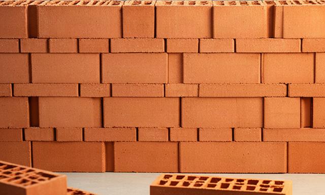 Mattoni eco-compatibili in plastica riciclata color terracotta disposti su una parete di prova